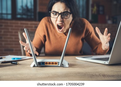 Angry Woman With Wifi Router In Office Background

