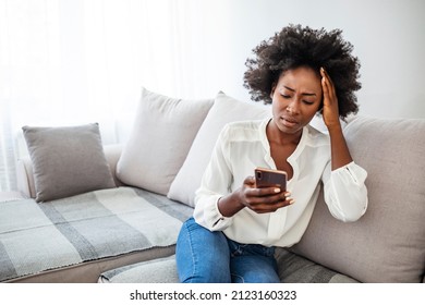 Angry Young African Woman Looking At Smartphone, Frustrated With No Signal Or Message Of Deception, Crazy Woman Disappointed Reading Bad News On Phone, Upset Girl Gets Negative Answer 