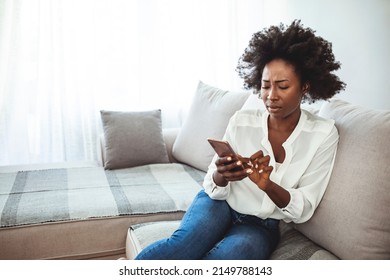 Angry Young African Woman Looking At Smartphone, Frustrated With No Signal Or Message Of Deception, Crazy Woman Disappointed Reading Bad News On Phone, Upset Girl Gets Negative Answer 