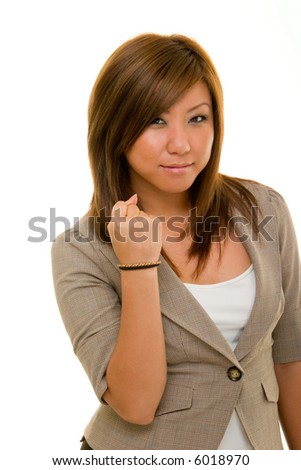 Angry young Asian woman in business suit holding her right hand in a fist.