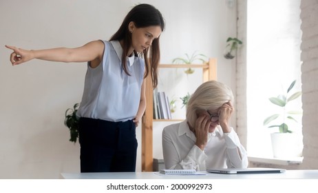 Angry Young Caucasian Female Boss Or CEO Ask Middle-aged Employee Leave Office. Mad Confident Businesswoman Fire Unhappy Senior Woman Worker, Dissatisfied With Work Results. Dismissal Concept.