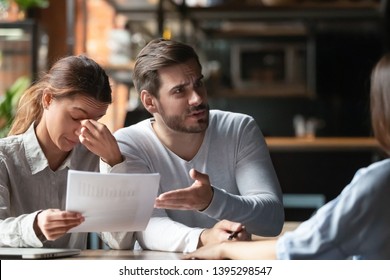 Angry young couple complaining, bad contract terms, outraged man arguing with manager or realtor, upset woman holding documents with stats, contract, dissatisfied clients demanding compensation