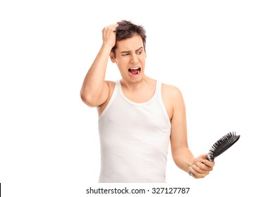 Angry Young Man Loosing Hair And Holding A Hairbrush Isolated On White Background