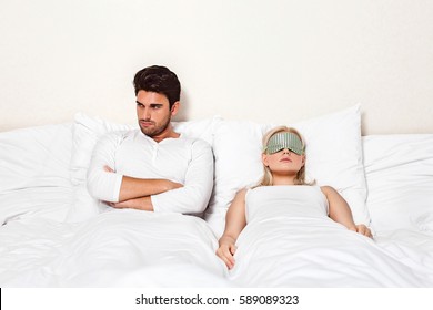 Angry Young Man With Woman Sleeping In Bed