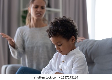 Angry Young Mother Argue Dispute With Little Biracial Son Behaving Ill Being Stubborn, Offended Small Boy Child Ignore Avoid Mad Mother Screaming Talking To Him. Parent Child Conflict Concept