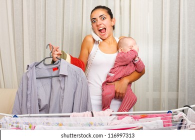 Angry Young Mother Fed Up With Doing The Laundry, Holding Her Crying Child And Talking On The Phone In The Same Time.