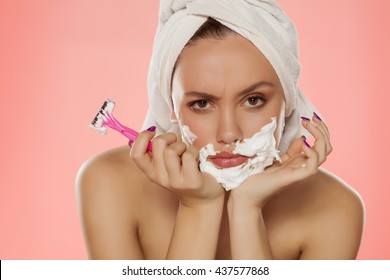 Angry Young Woman With Foam On The Face And A Razor In Her Hand