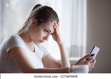 Angry young woman looking at smartphone frustrated by no signal or scam message, mad female disappointed by bad news reading on phone, upset girl get negative or rejection response on mobile