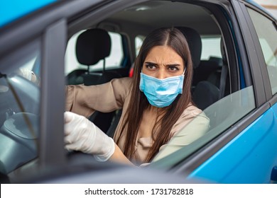Angry young woman shouting and gesturing while driving a car. Woman in protective mask driving a car on road. Young woman protect her self from Corona virus wearing protective mask