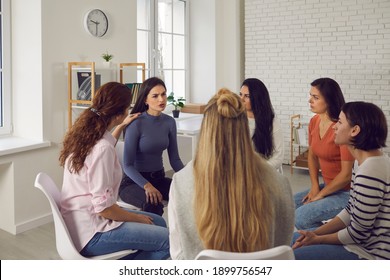 Angry Young Woman Telling Shocking Story In Therapy Session Or Support Group Meeting. Female Friends Talk, Share Bad News, Discuss Life Situations, Give Advice And Help Each Other Cope With Problems