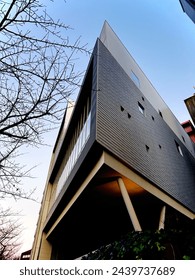 Angular architecture stretches into the sky, its lines intersecting at dynamic angles, creating a visually captivating spectacle that dominates the skyline.