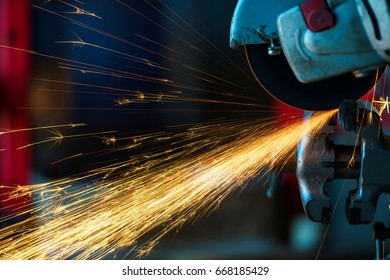 Angular grinding machine is cutting the metal and a lot of sparks flying around - Powered by Shutterstock