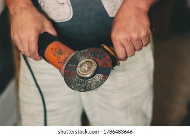 Angular grinding machine in a hands of carpenter.