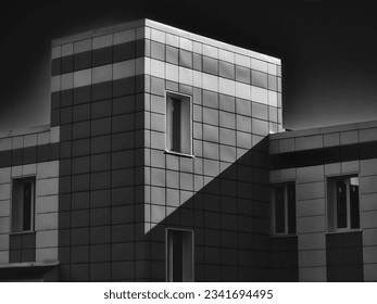 Angular modern building lined with metal panels, rectangular windows, black and white photography