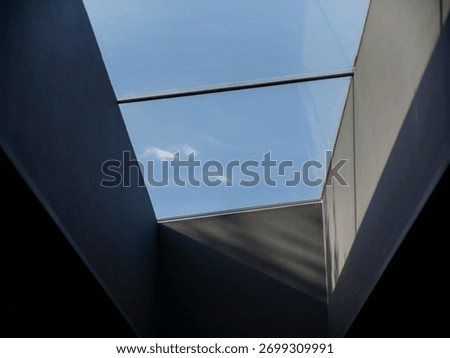 Angular modern skylight with blue sky view framed by clean geometric architectural lines