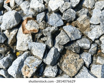 Angular mountain stone aggregate close-up. Interlocking crushed rock gravel texture for superior erosion control barriers and heavy duty roadbeds