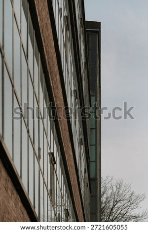 Angular perspective of industrial brick building facade showing window grid pattern and architectural detail