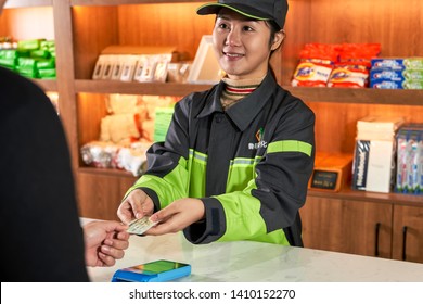 Anhui, Asia, China, December 10, 2018: Luming Petrochemical's Gas Station Female Employee Is Receiving The Customer's Bank Card At The Counter To Prepare For Settlement.