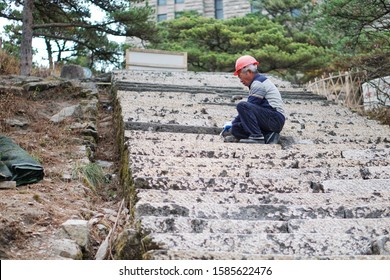 Anhui Province, China, on December 11, 2019 at approximately 15.30 on the Huangshan mountain.  The laborers were carving the stone stairs used for tourists to walk up the hill.  From smooth to rough s