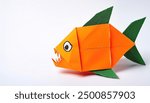 Animal aquatic water concept origami isolated on white background of a cute, adorable, red bellied piranha fish - Pygocentrus nattereri - with teeth. with copy space, simple starter craft for kids