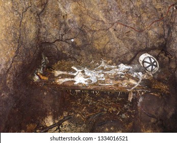 Animal bones arranged as human skeleton of a miner in a cave on a bench with helmet an shoes. scarry Halloween theme
