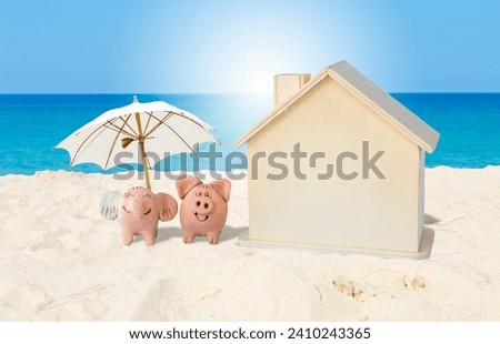 Animal clay doll with beach umbrella and wooden house model on tropical beach, piggy bank on the beach, saving for property investment
