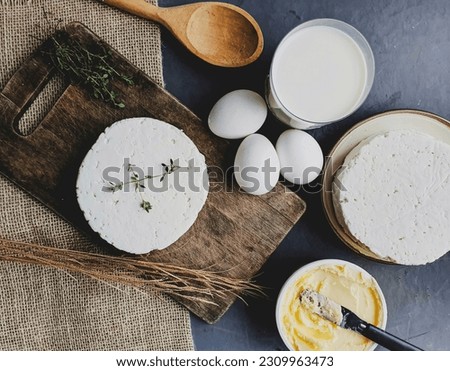  animal derived foods, milk, eggs , butter  and white cheese and  rustic background