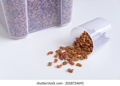 Animal Feed, Ready To Eat Pellets Food Multi Nutrients For Cat And Dogs Or Pet, Dried Storage Or Container Box With Measuring Cup On White Background.