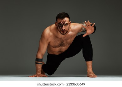 Animal Instinct Fitness Instructor Sportsman Showing His Incredible Flexibility With An Animal Flow Move In Studio Against A Gray Background