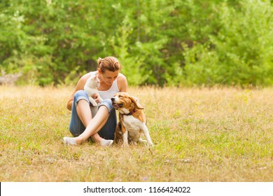 Animal Lover Woman Animal Lover Sitting On Grass With Her Pets