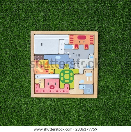 Animal themed wooden puzzle on grass. Dimensional thinking. educational activity. Mental skill development. Children's toys.