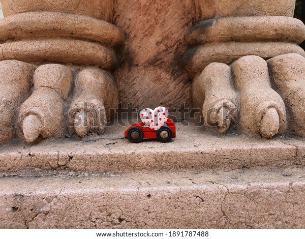 animal toenail sculpture and Red toy car with white\
dotted heart shape