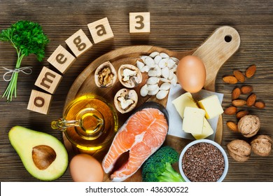 Animal and vegetable sources of omega-3 acids as salmon, avocado, linseed, eggs, butter, walnuts, almonds, pumpkin seeds, parsley leaves and rapeseed oil - Shutterstock ID 436300522