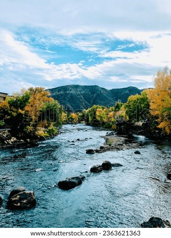 Animas river in Durango, Colorado with green and golden trees, mountains and rocks