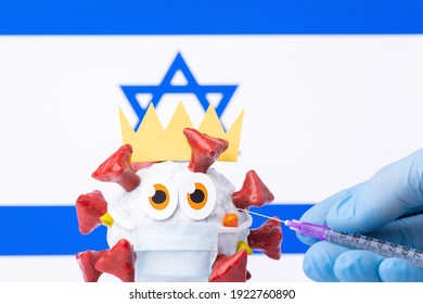 Animated coronavirus model with crown and medical mask with a flag of Israel in background. Hand of a doctor holding syringe with vaccine against Covid-19 virus.