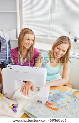 Animated female friends sewing clothes together at home in the kitchen