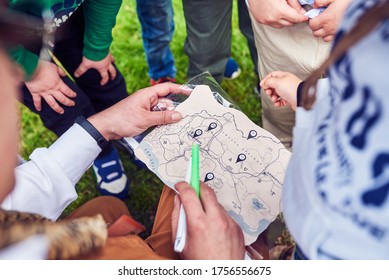The animator, along with the children, is trying to solve the children's treasure map. A game for young children, in nature. Parents are free. - Shutterstock ID 1756556675