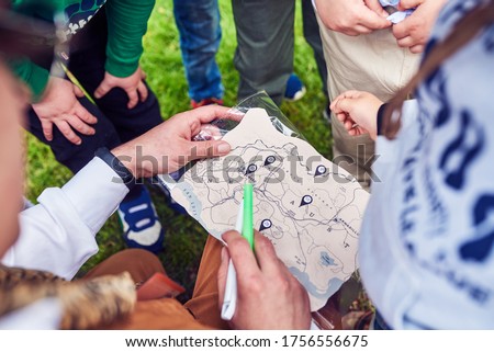 The animator, along with the children, is trying to solve the children's treasure map. A game for young children, in nature. Parents are free.