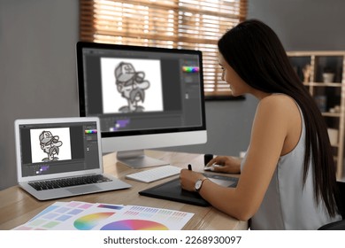 Animator working with graphic tablet, computer and laptop. Illustrations on screens - Powered by Shutterstock