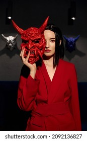 Anime Woman In A Red Suit With Short Hair Cut, Black Hair. A Killer Girl In A Red Jacket With A Red Japan Mask. Beauty Portrait