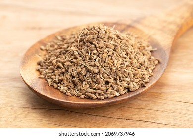 Anise spice seeds in wooden spoon on wooden table. Close up