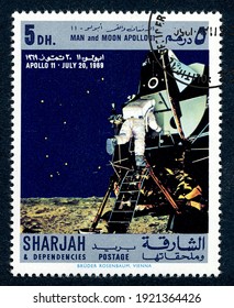 Ankara, Turkey - 21 February 2021: A Postage Stamp Printed In Sharjah Shows First Man On The Steps Of Lunar Capsule On The Moon. Circa 1969