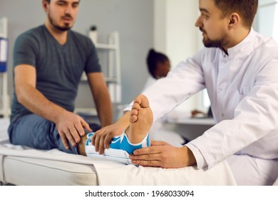 Ankle Injury Bone Fracture, Emergency First Aid Splint, Medicine And Healthcare. Doctor Examine Patient With Broken Leg Trauma Orthopedic Bandage Lying On Hospital Bed. Focus On Foot In Care Bandage