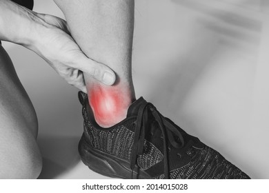 Ankle, joint pain, and tendon problem. Athlete man touching ankle