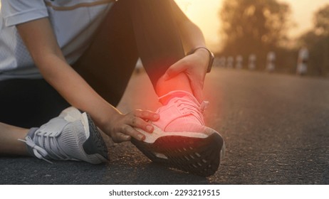 Ankle twist sprain accident in sport exercise running jogging.low key lighting.
