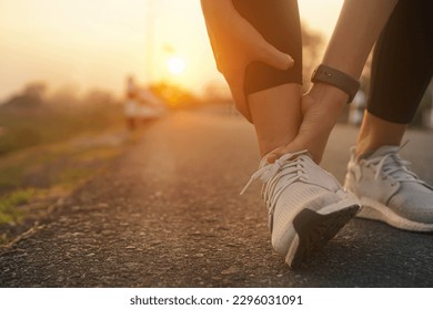 Ankle twist sprain accident in sport exercise running jogging.low key lighting.