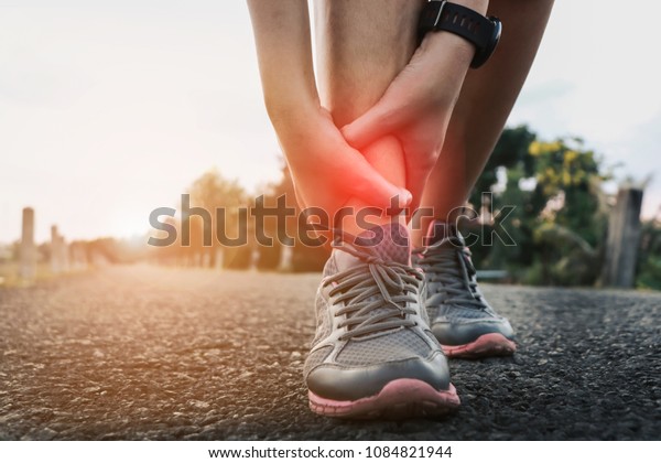 Ankle twist sprain accident in sport\
exercise running jogging.sprain or cramp Overtrained injured person\
when training exercising or running\
outdoors.