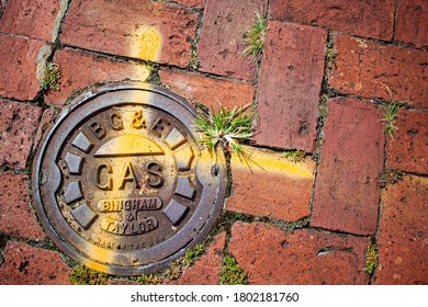 Annapolis, MD 08/21/2020: Close up image of a manhole cover belonging to Baltimore Gas and Electric Company. The heavy duty metal cover is on top of an underground gas pipeline on cobblestone pavement