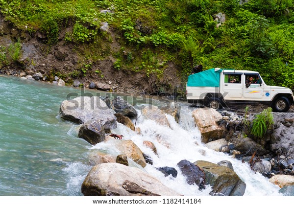 Annapurna Conservation Area, Nepal - July 18, 2018 :\
Off road vehicles with tourists crossing a river on Annapurna\
track, a hotspot destination for mountaineers and Nepal\'s largest\
protected area