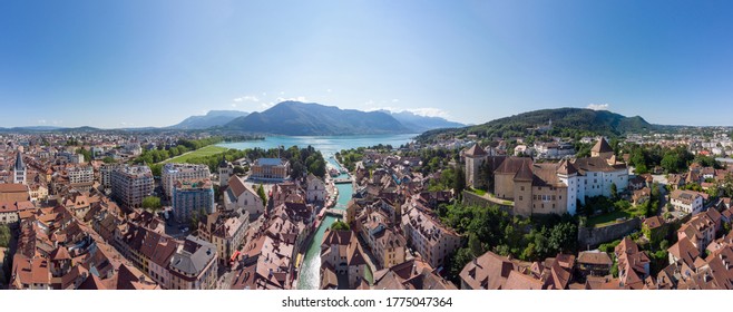 Annecy city center panoramic aerial view with the old town, castle, Thiou river and mountains surrounding the lake, beautiful summer vacation tourism destination in France, Europe
